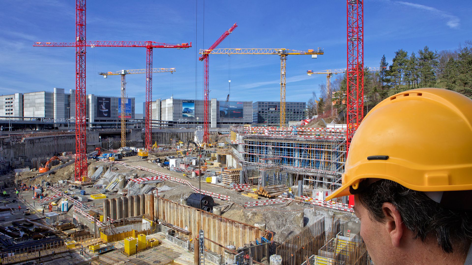 Mann mit Helm vor Baustelle