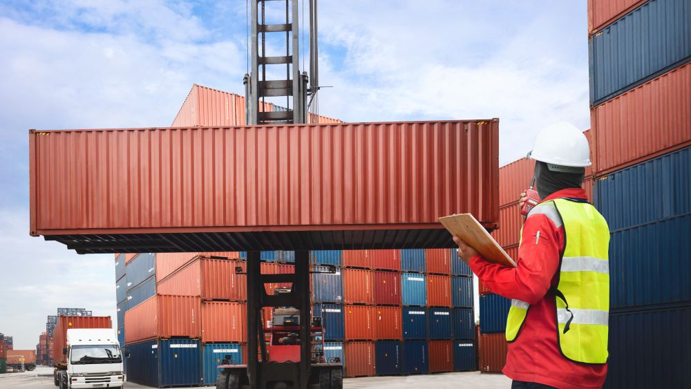 Foreman control loading containers box from cargo freight ship