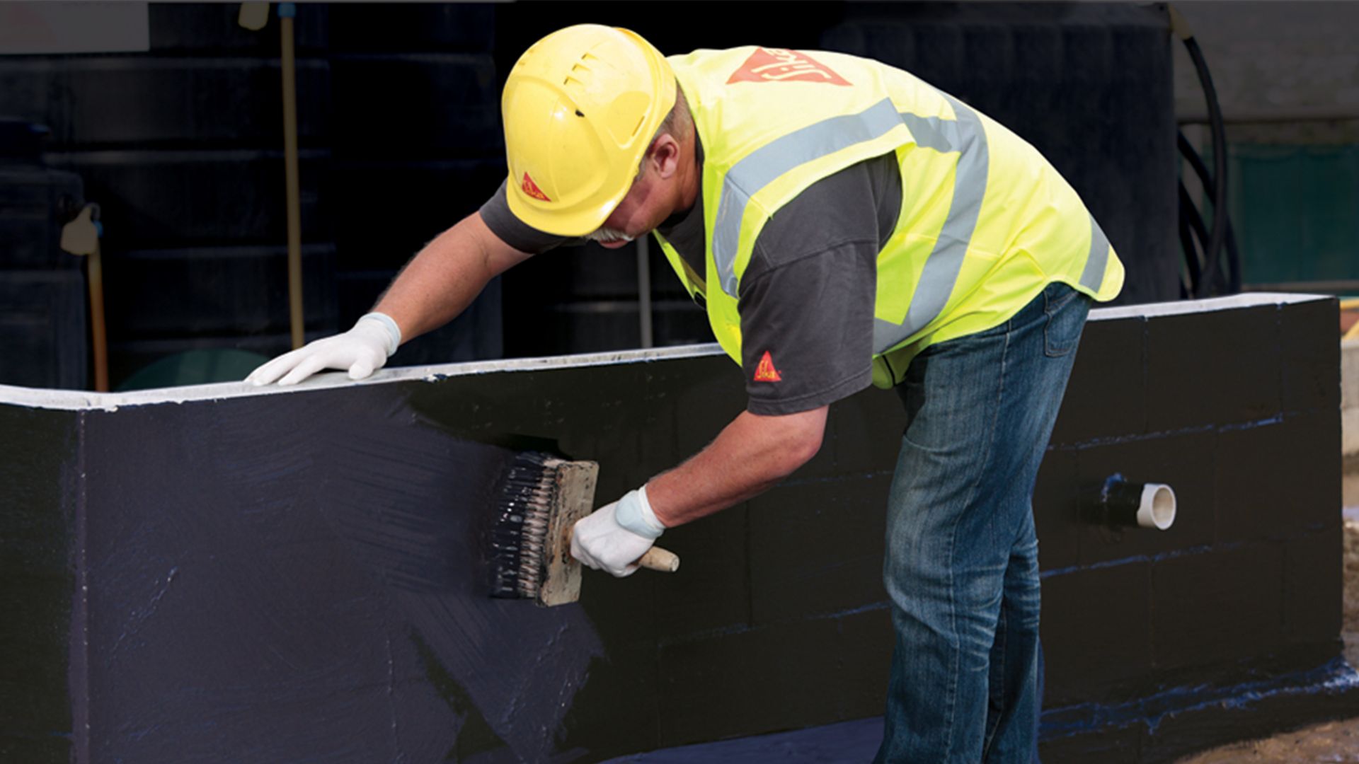 Expert applies Sika BlackSeal Elastic for below ground waterproofing of concrete basement wall