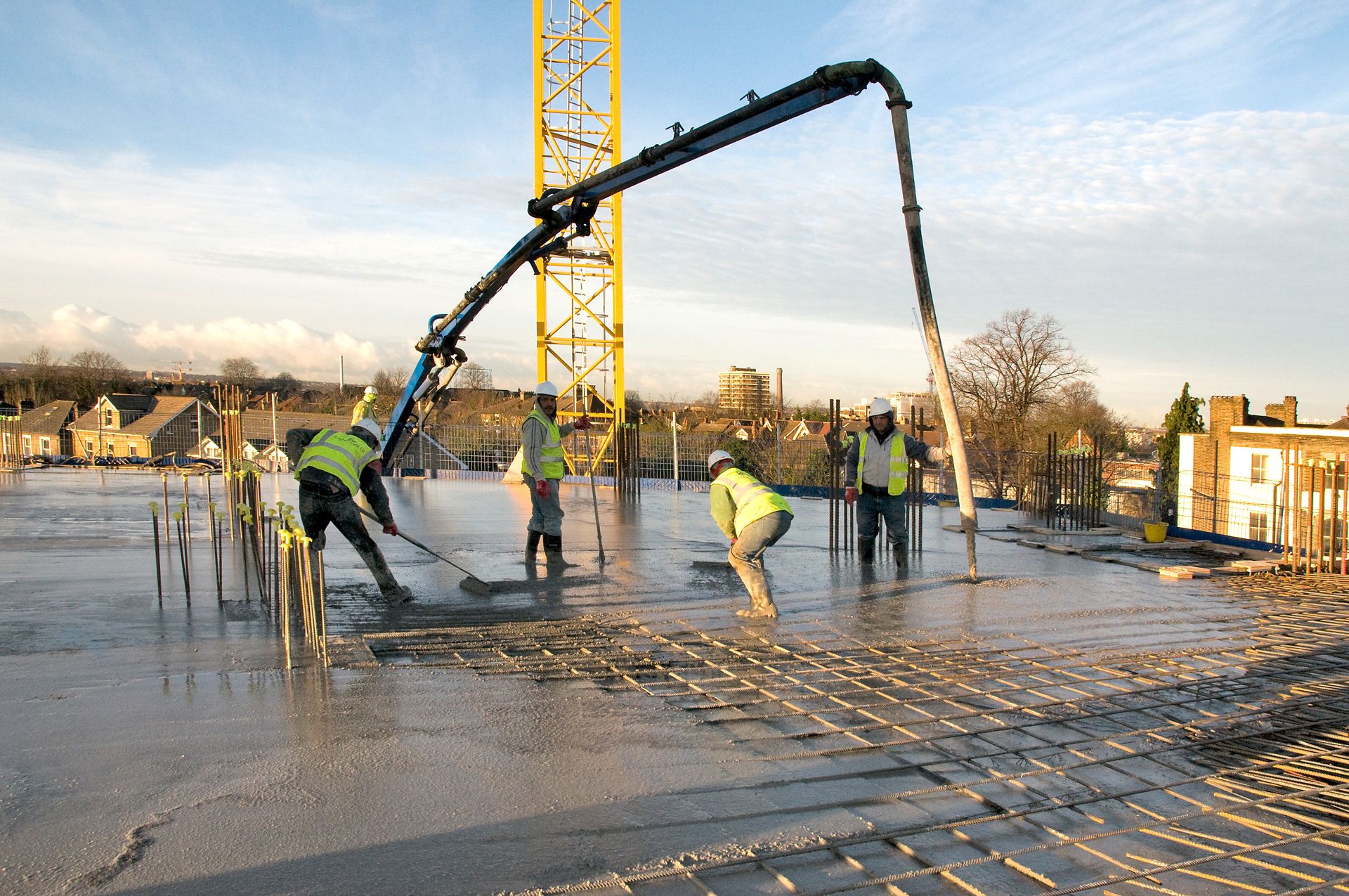 Concrete pump menyalurkan beton ready mix ke pelat lantai proyek