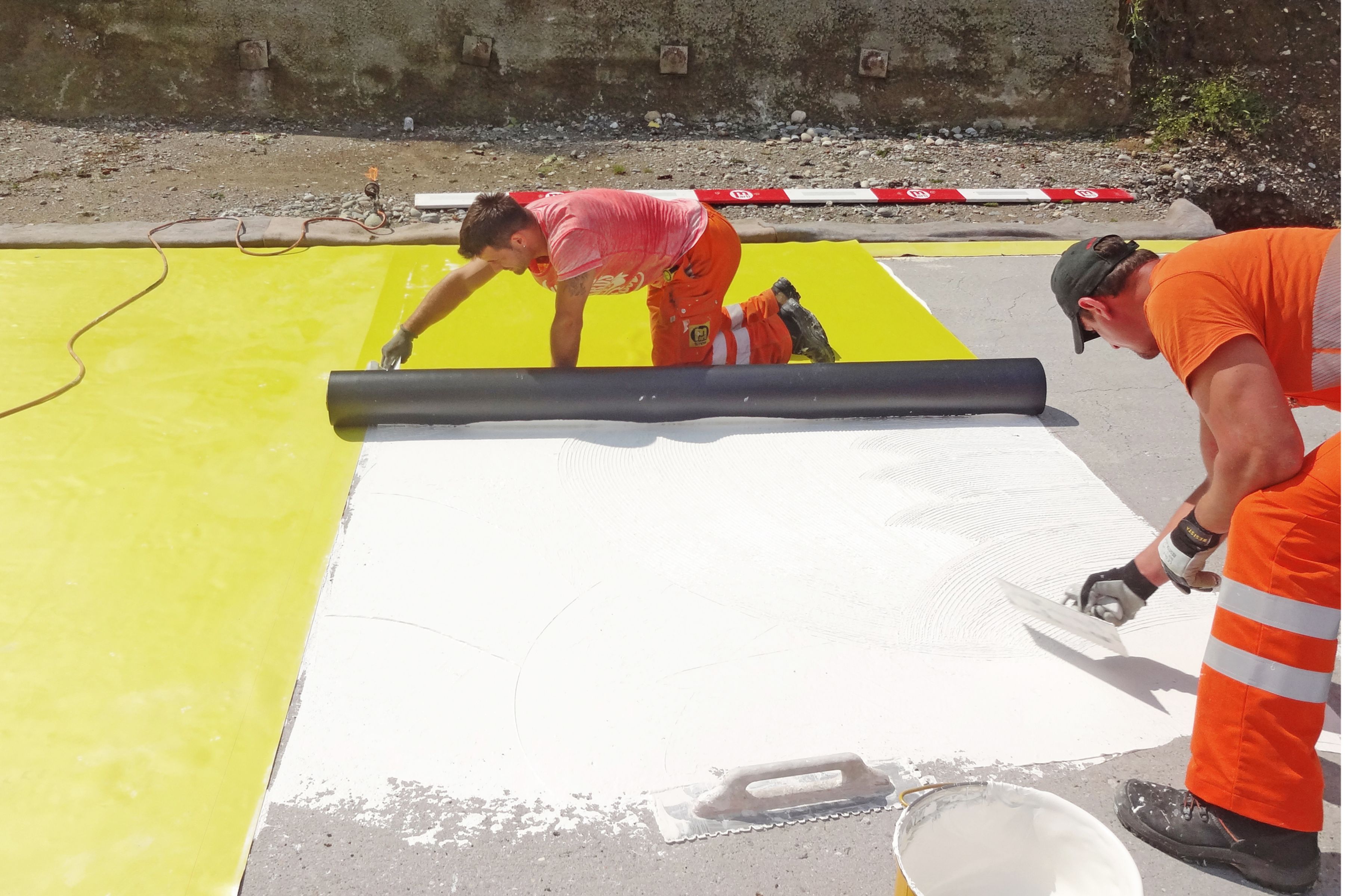 Kleber Verteilen und Kunststoff-dichtungsbahn Einrollen。