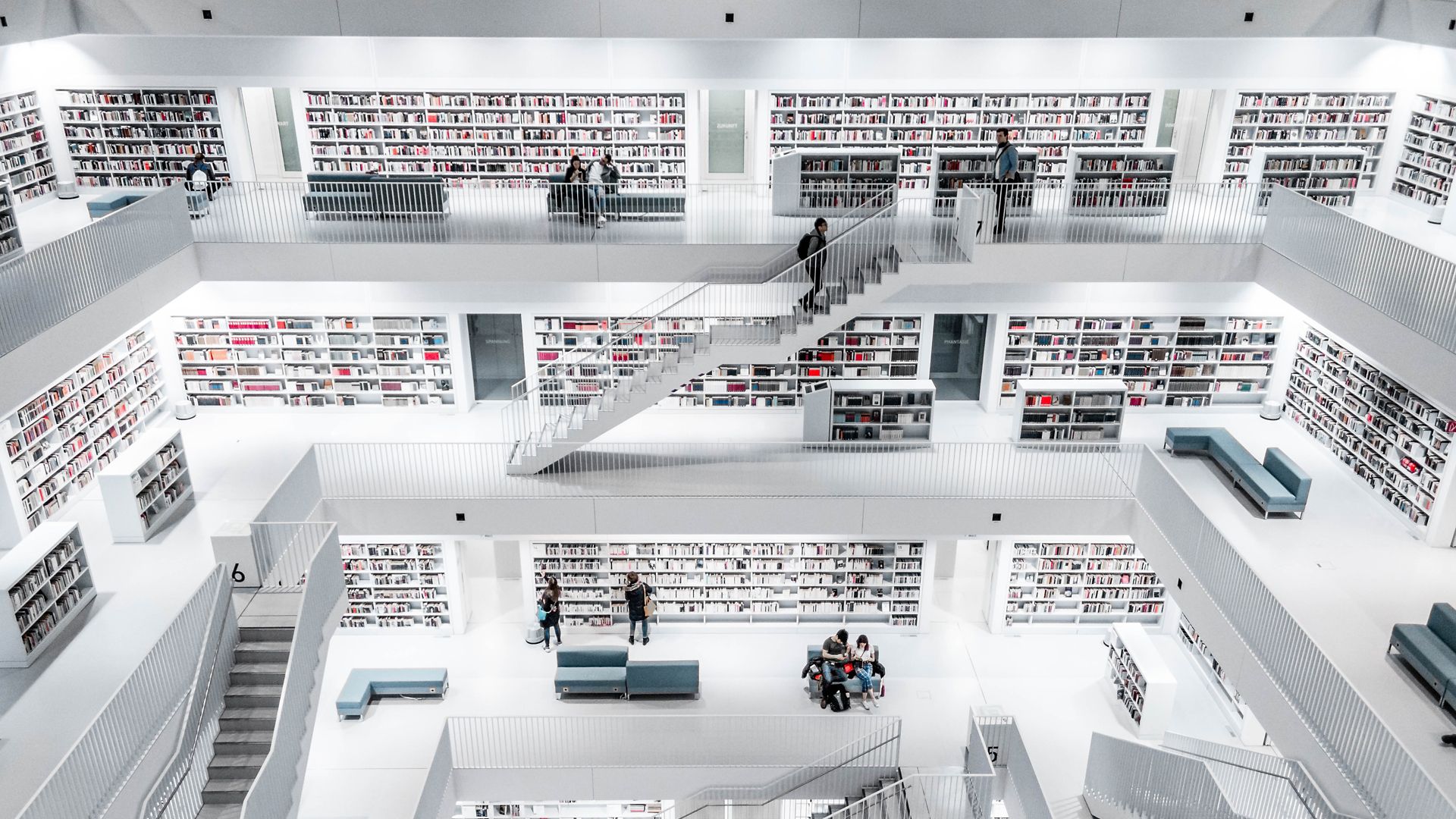 People browsing modern library, photo by Christian Wiediger on Unsplash