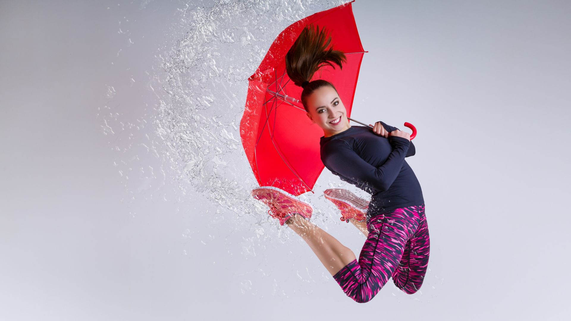 Woman in jump with an umbrella. Frozen motion.