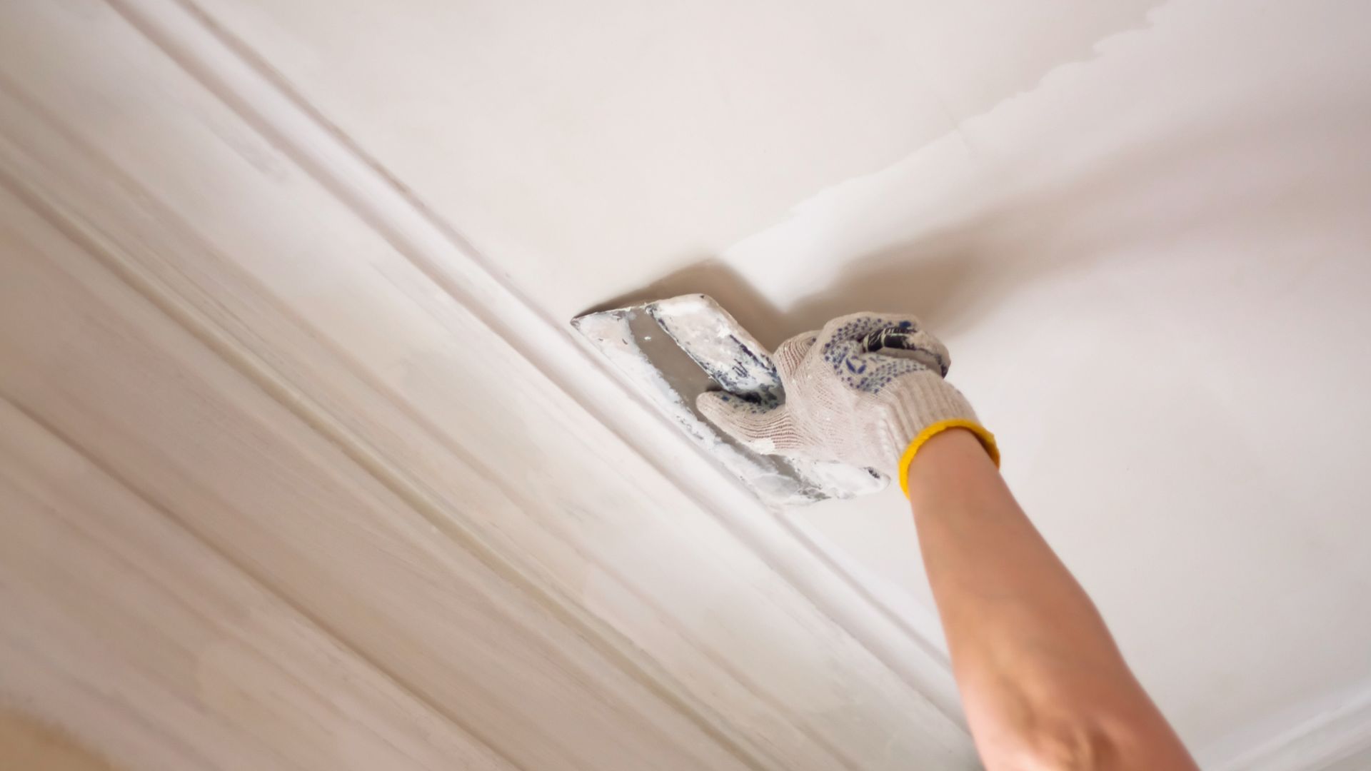 Plasterer putty joints with surfacer.  Leveling the ceiling with a spatula.