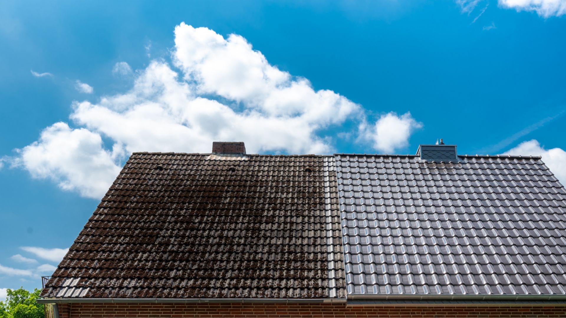 A half cleaned house roof shows the before and after effect of a roof cleaning.