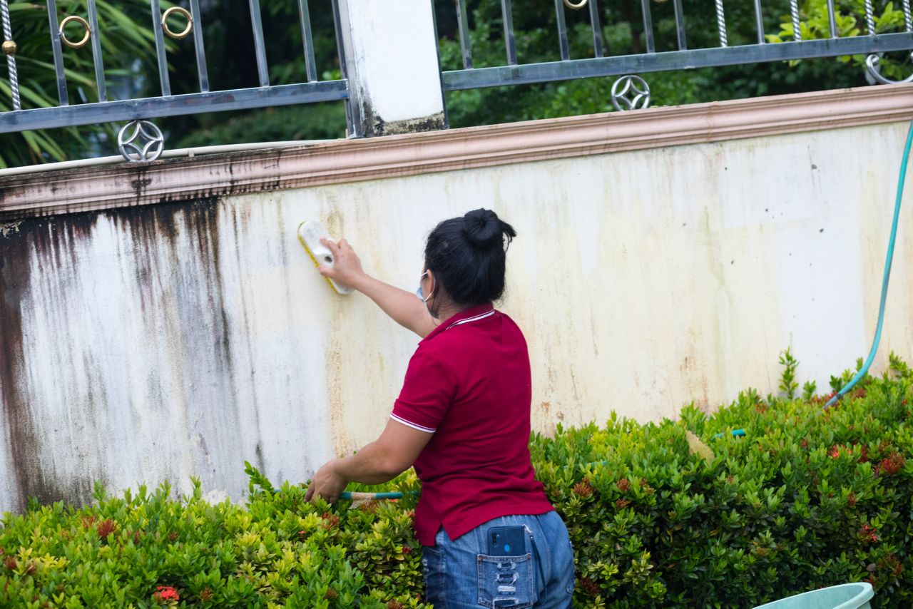 Une femme nettoie un mur