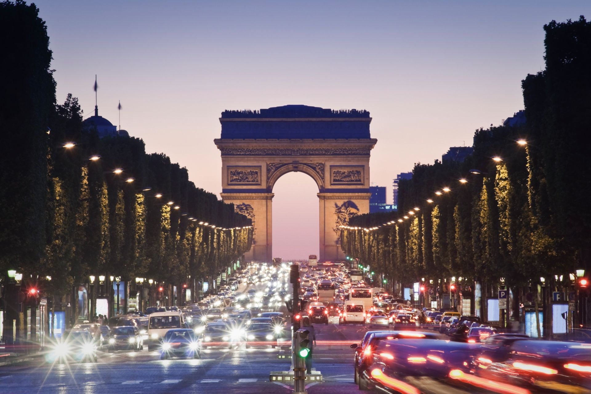 Pretty night time illuminations of the Impressive Arc de Triomphe (1833) along the famous tree lined Avenue des Champs-Elysees in Paris. ProPhoto profile for precise color reproduction.