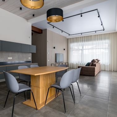 Grey kitchen furniture. Built-in household techie. Black with a gold chandelier over the table. panoramic windows. Light interior. Ceiling sweats. Modern furniture for the dining room.