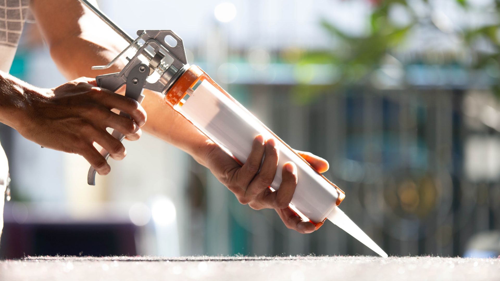 Men's hand uses silicone adhesive with adhesive to connect the mirror with aluminum.