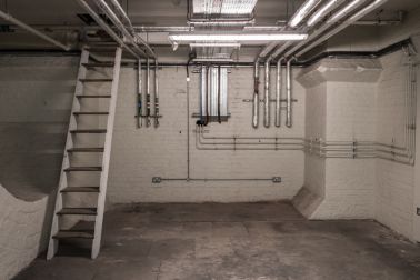 Modern plumbing in the basement of an old building.