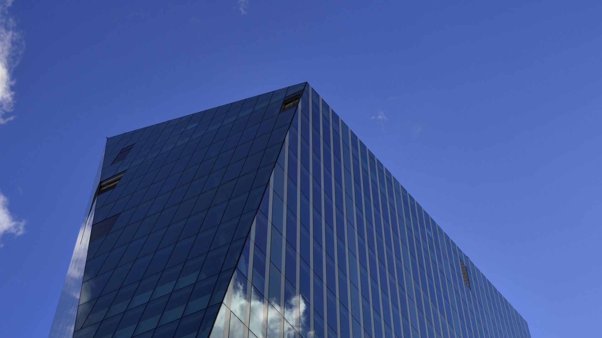 High-rise building with glass facade with cloud reflection