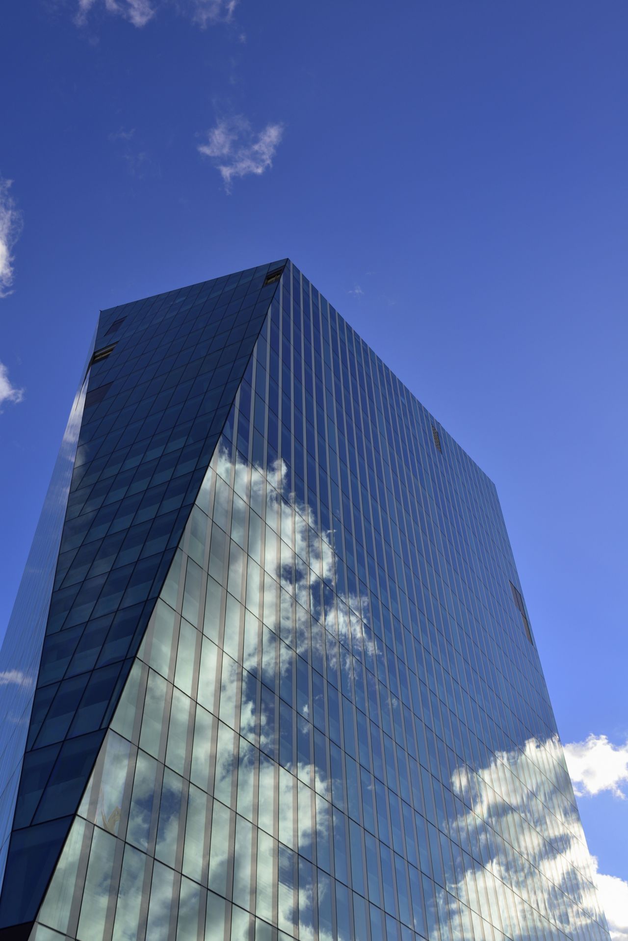 High-rise building with glass facade with cloud reflection