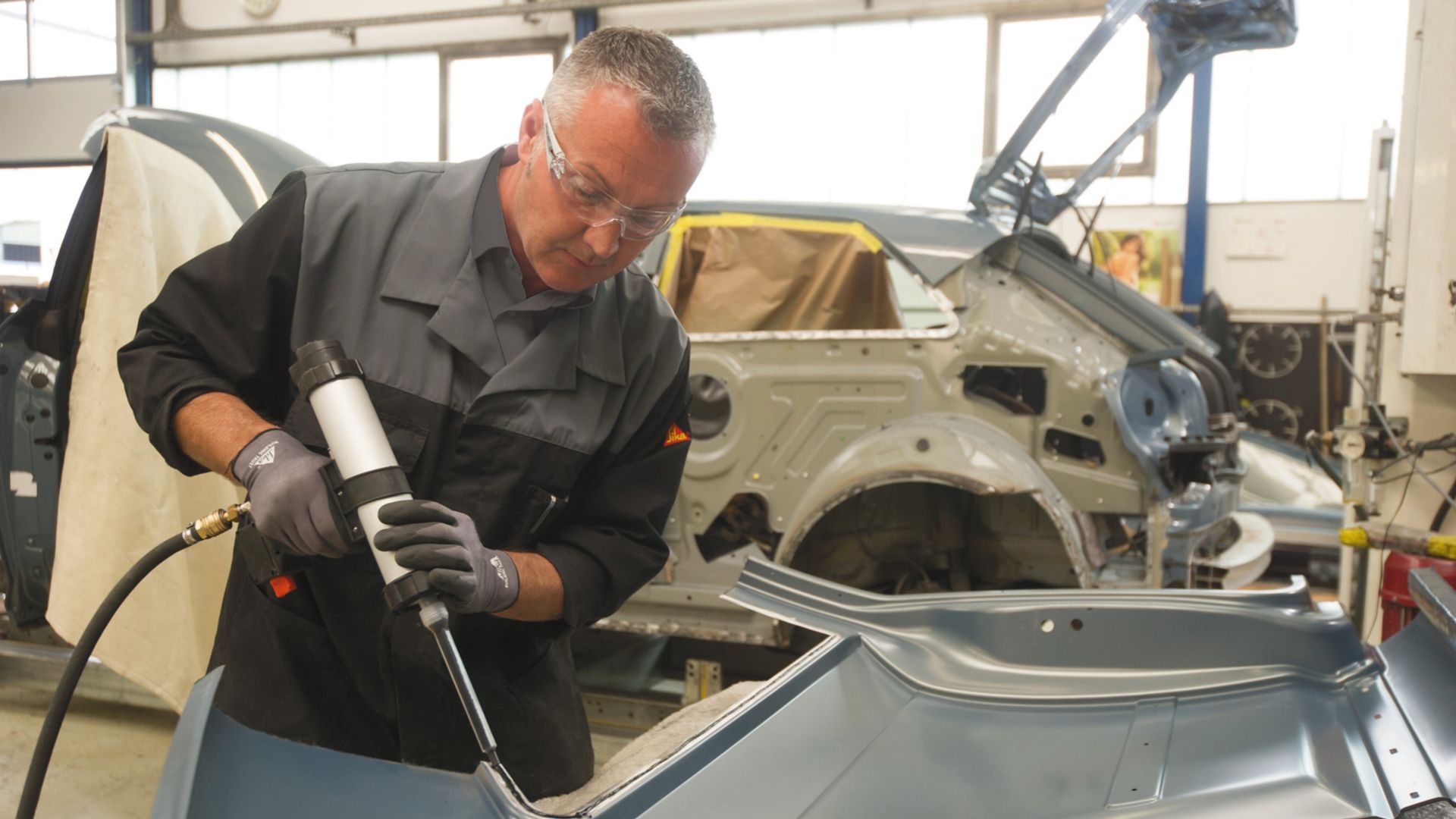 Car body repair with adhesive in a car factory 