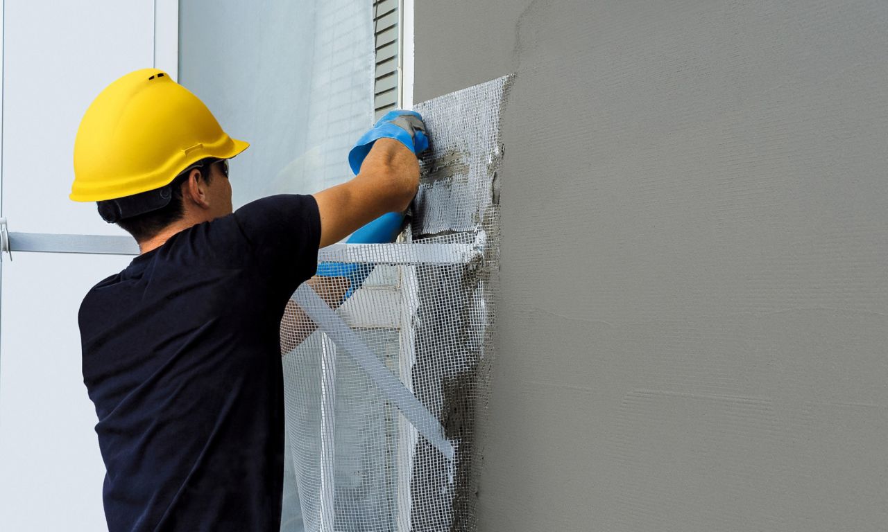 作業員がシーカの製品を使ってビルの外壁を仕上げています。