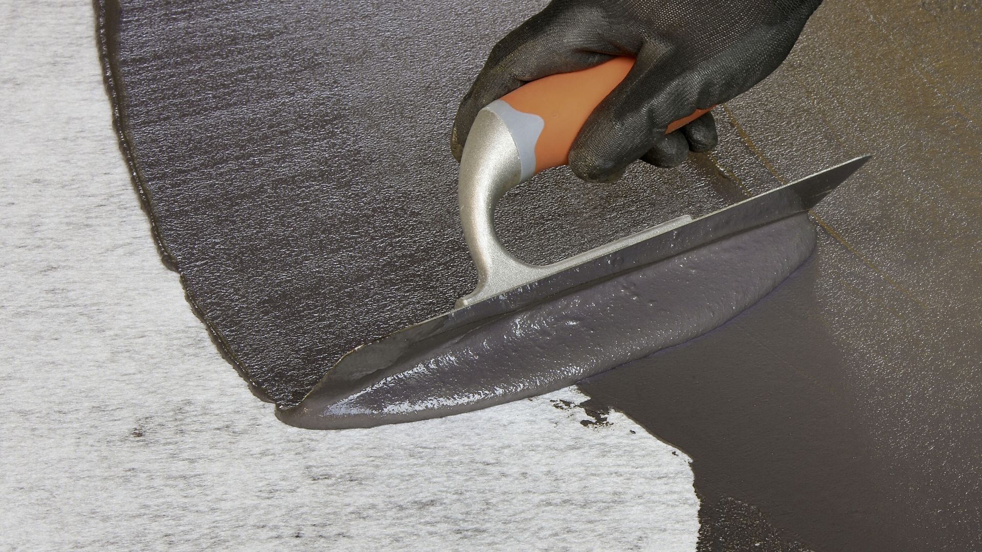 Application of cold-applied bitumen membrane with a hand trowel	 