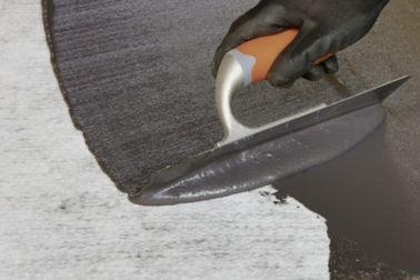 Application of cold-applied bitumen membrane with a hand trowel	 