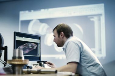 在图画绘制汽车部分的CAD计算机前面的人