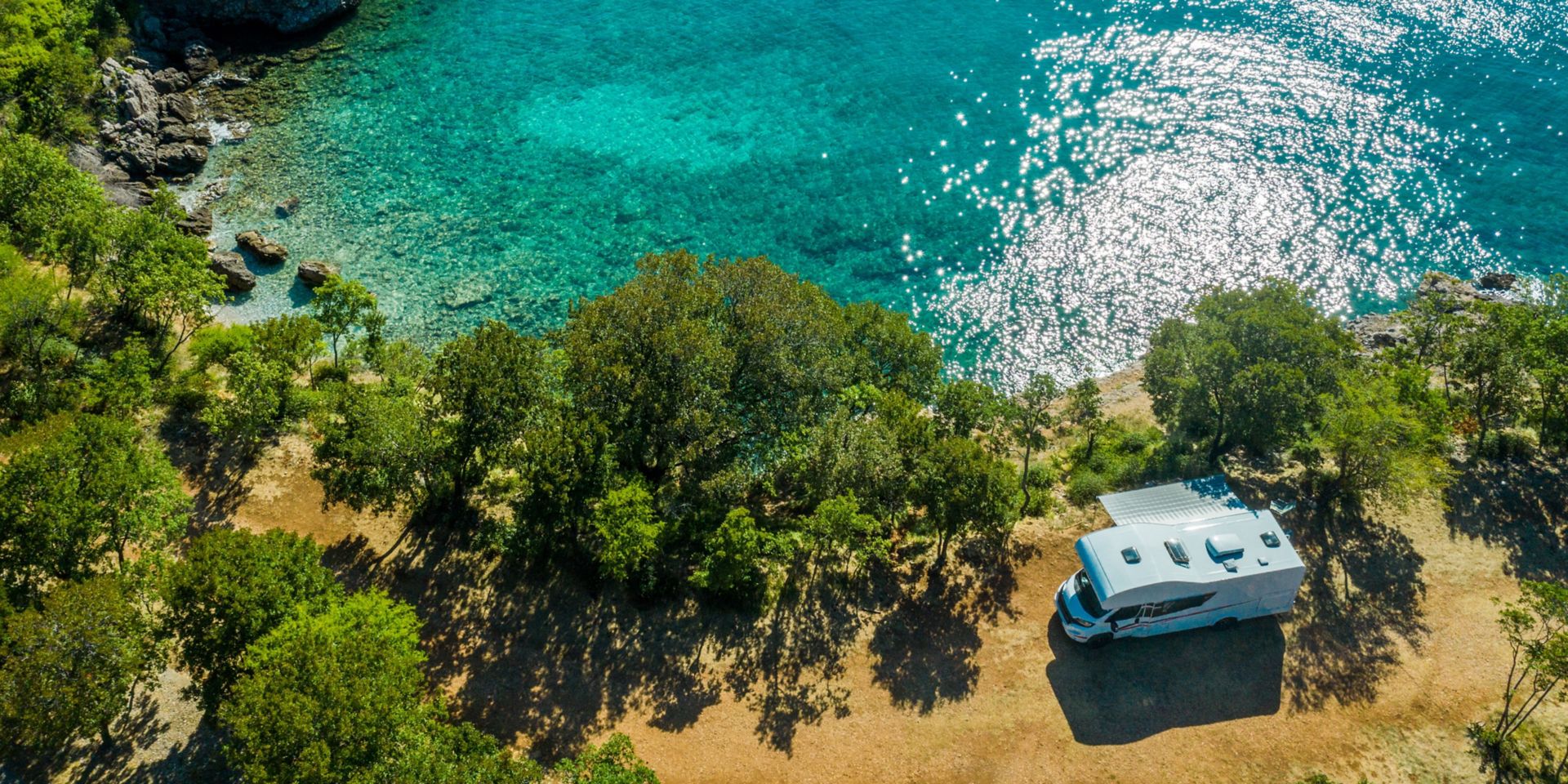 Aerial Photo of Scenic Sea Front RV Campsite. Modern Motorhome Camper Van on the Mediterranean Sea Croatian Coast. Vacation on the Road. Turquoise Bay.