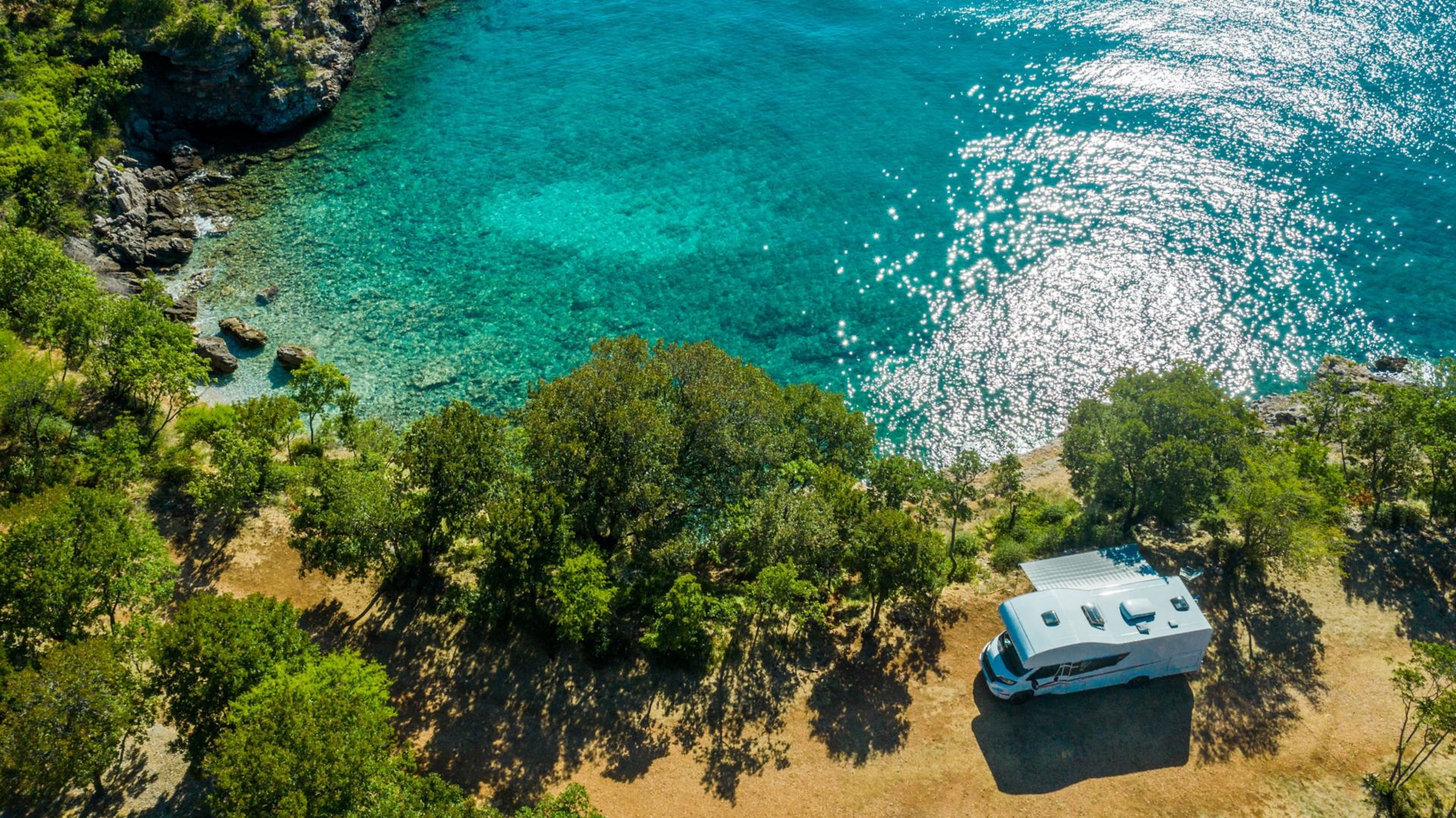 Aerial Photo of Scenic Sea Front RV Campsite. Modern Motorhome Camper Van on the Mediterranean Sea Croatian Coast. Vacation on the Road. Turquoise Bay.