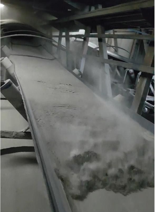 Backflow of cement on an inclined conveyor belt due to high powder flow