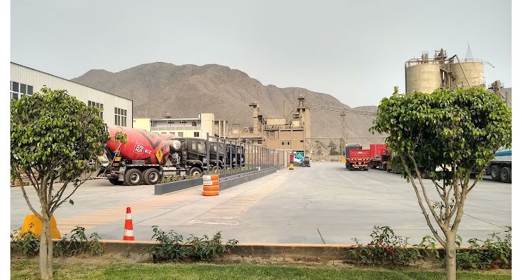 Concrete cement trucks parked in front of Caliza Cemento Inca Cement Plant in Lima, Peru with mountains