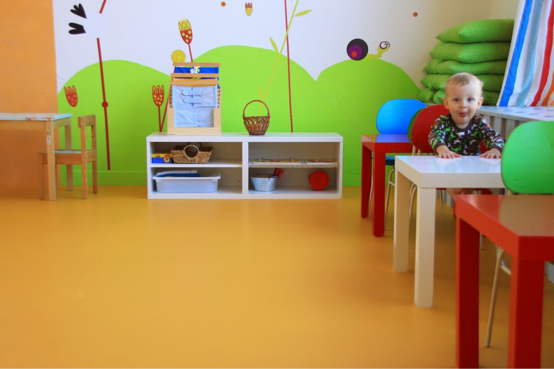 Sika ComfortFloor® orange floor in daycare with baby sitting on chair