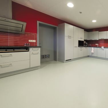 Sika ComfortFloor® grey floor in modern kitchen with red walls