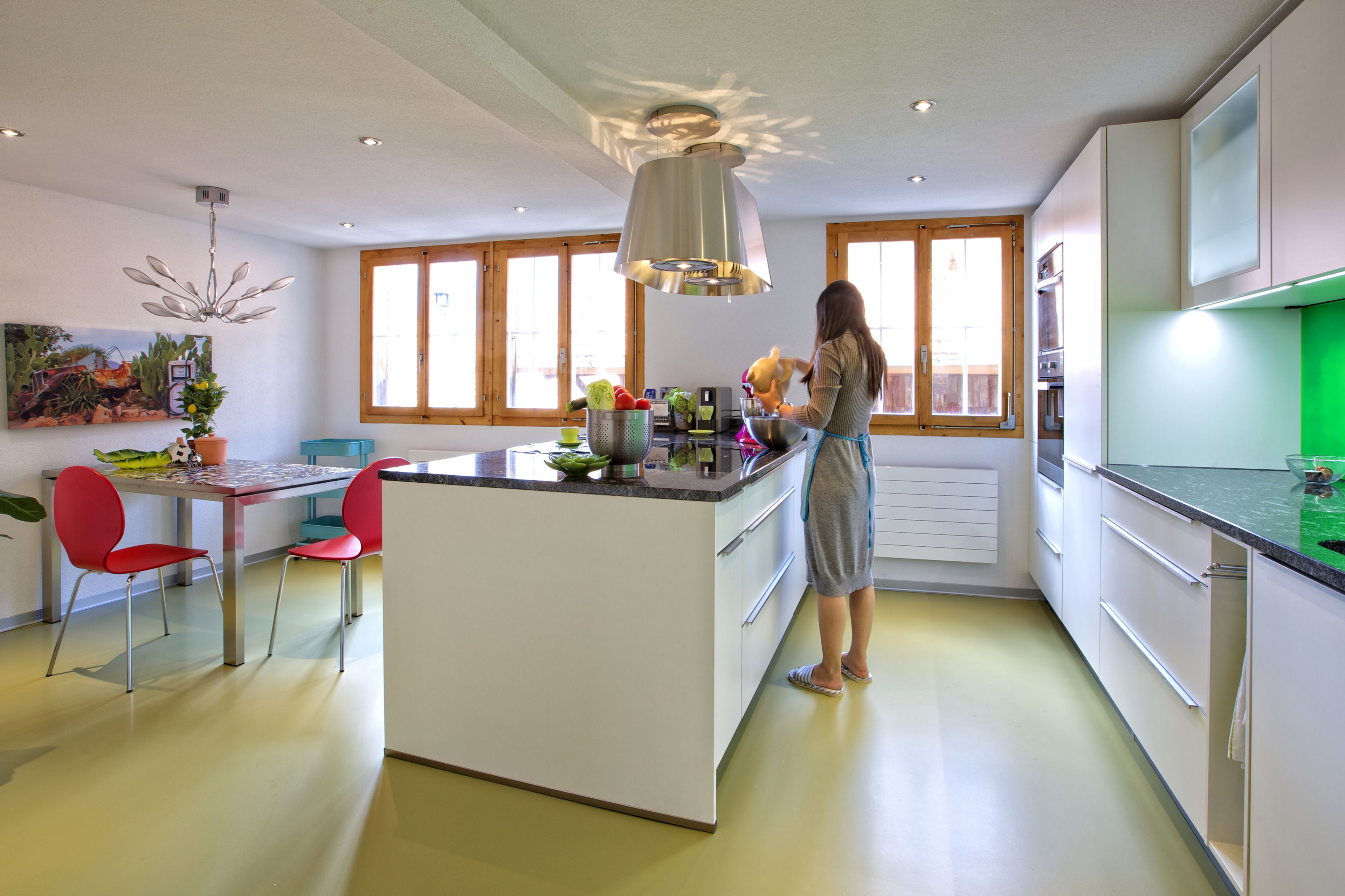 Sika ComfortFloor® green floor in kitchen with woman preparing food
