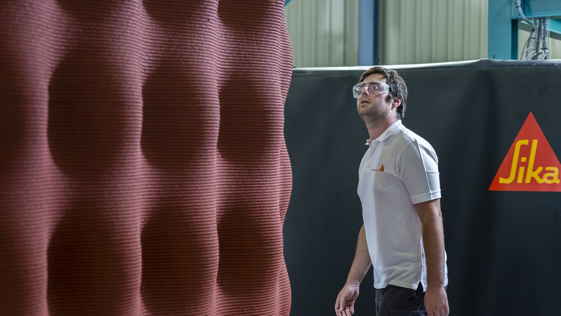 Man assessing 3D printed concrete element produced with Sika admixtures