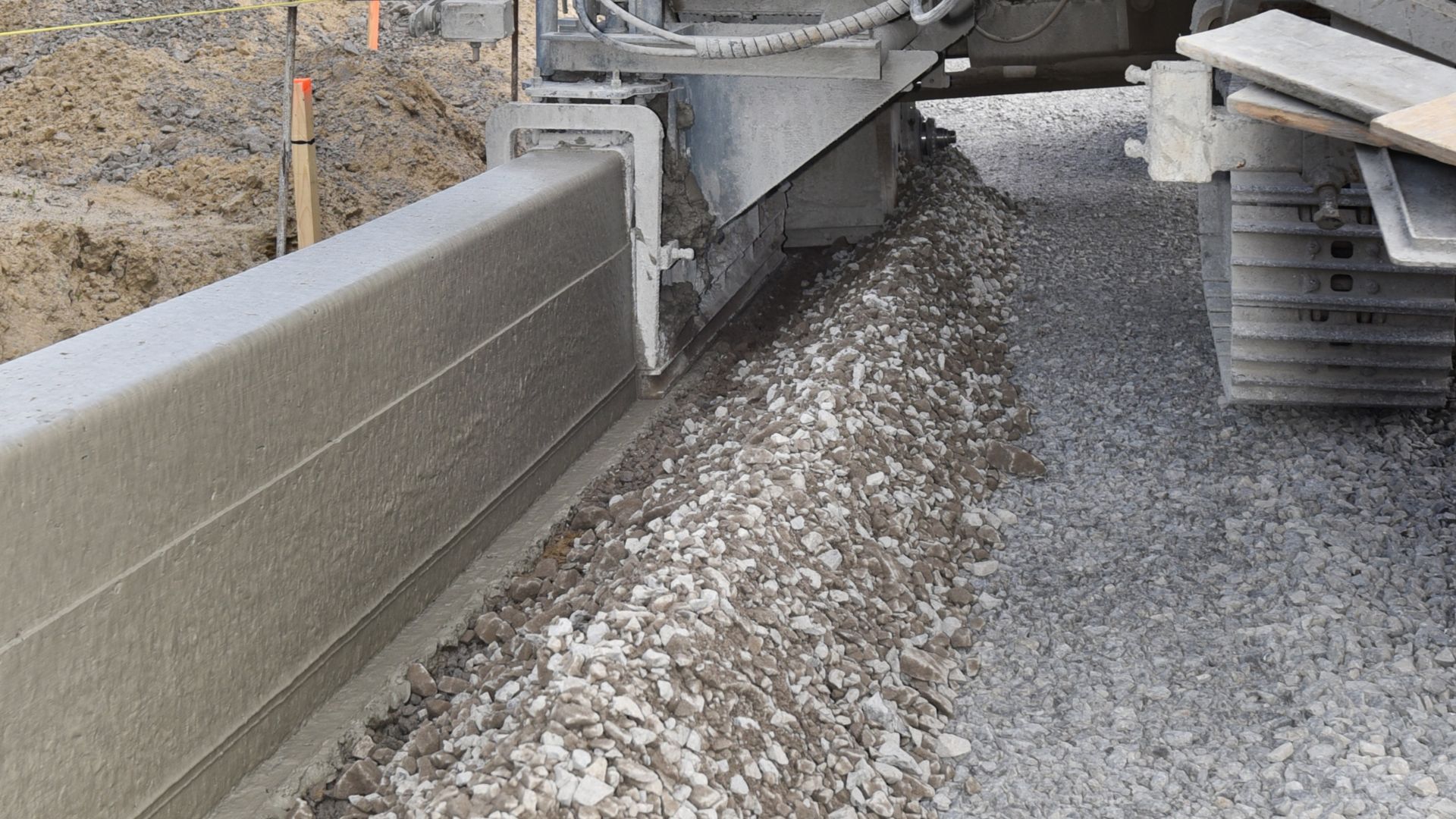 Machine extruding concrete on construction site with concrete fibers