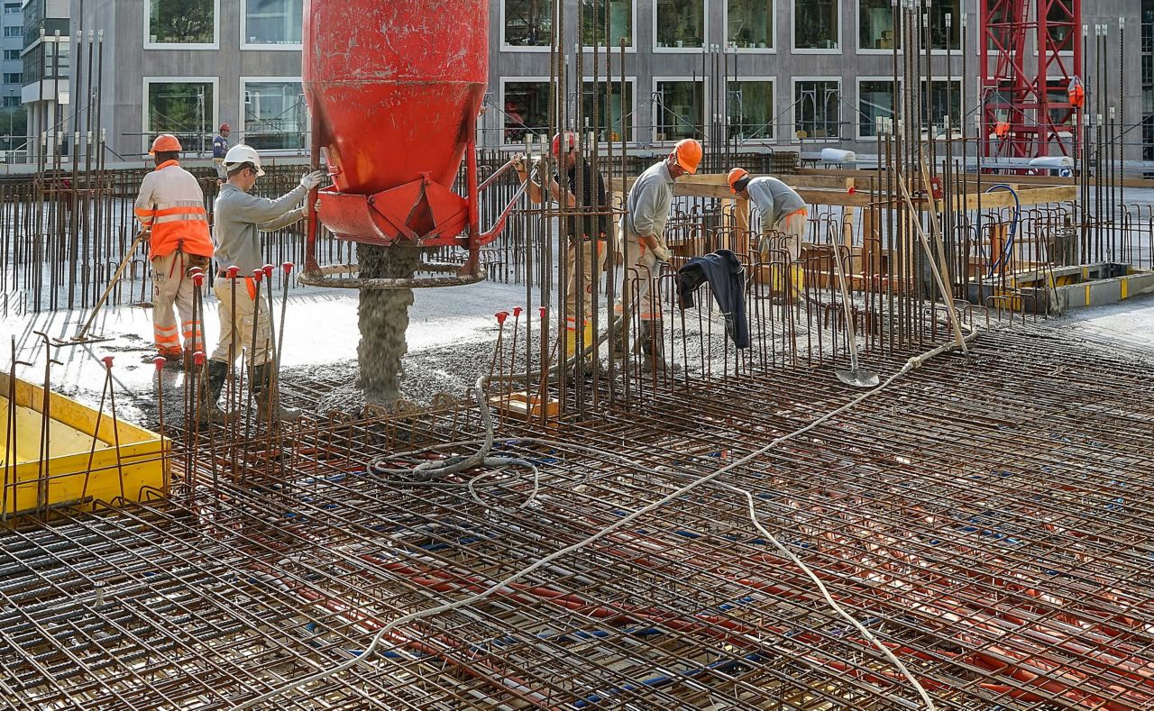 Worker men pouring fresh concrete into rebar for Limmat building in Zurich, Switzerland