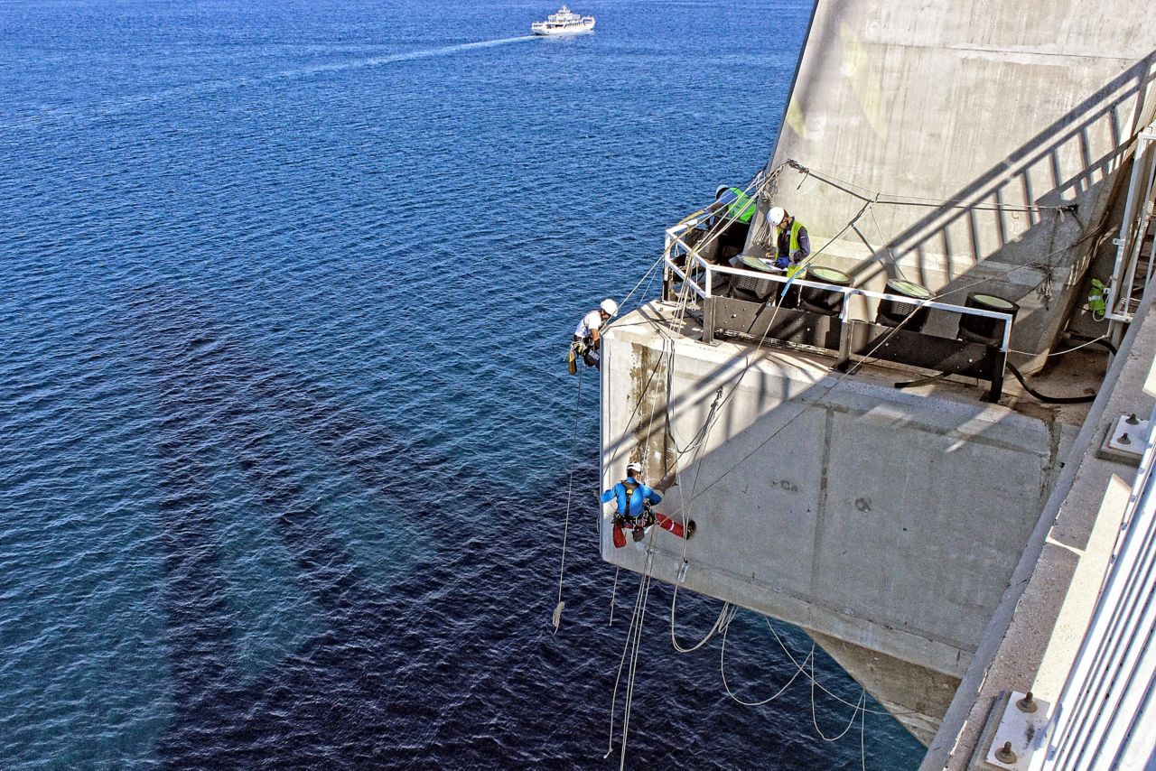 一名男子正在修理一座悬挂在海上的混凝土桥