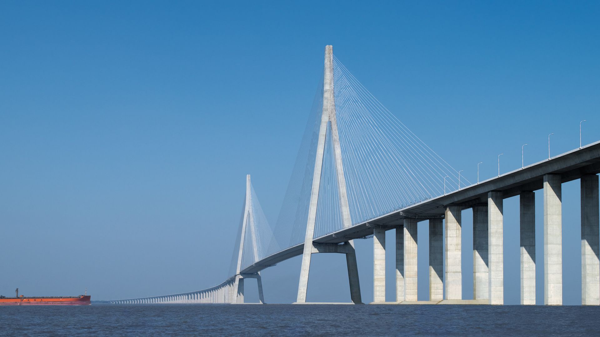 Concrete Sutong Bridge in China with blue sky and red boat