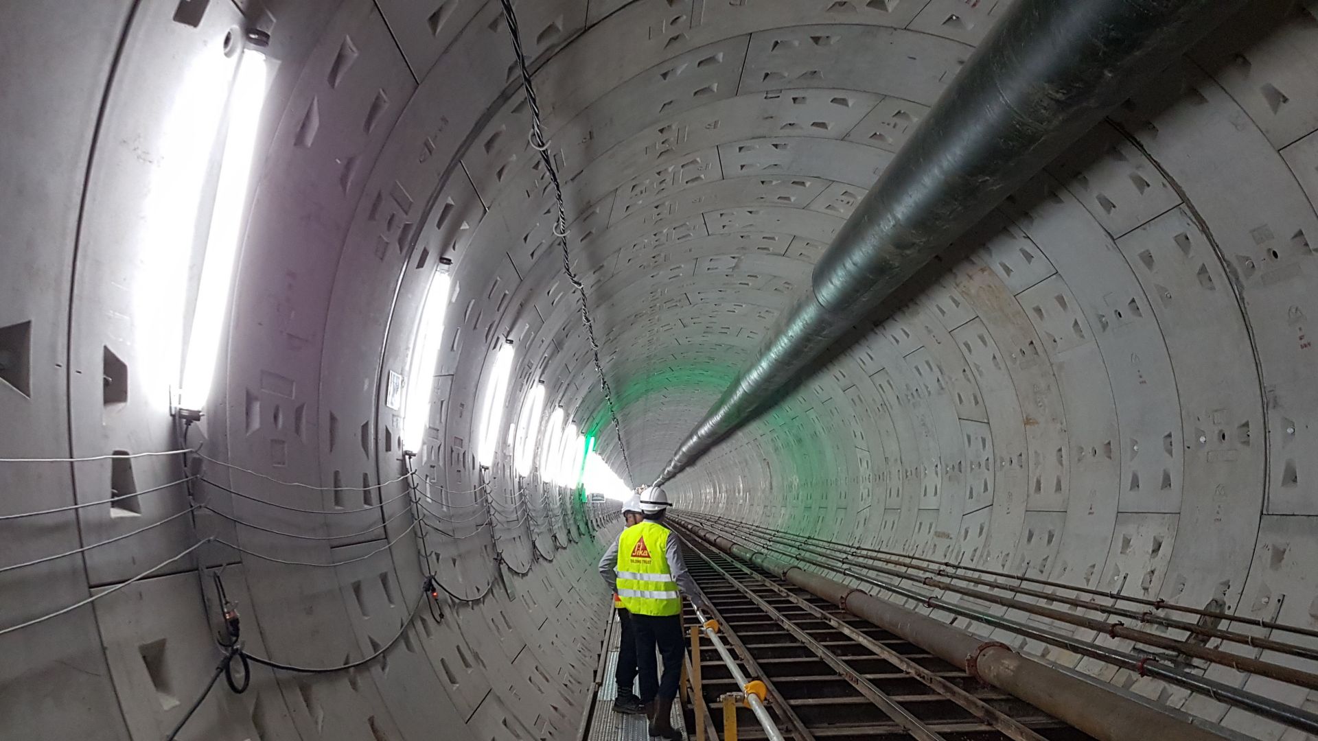 Sika man standing in concrete tunnel built with tunnel boring machine pipes and Sika concrete admixtures