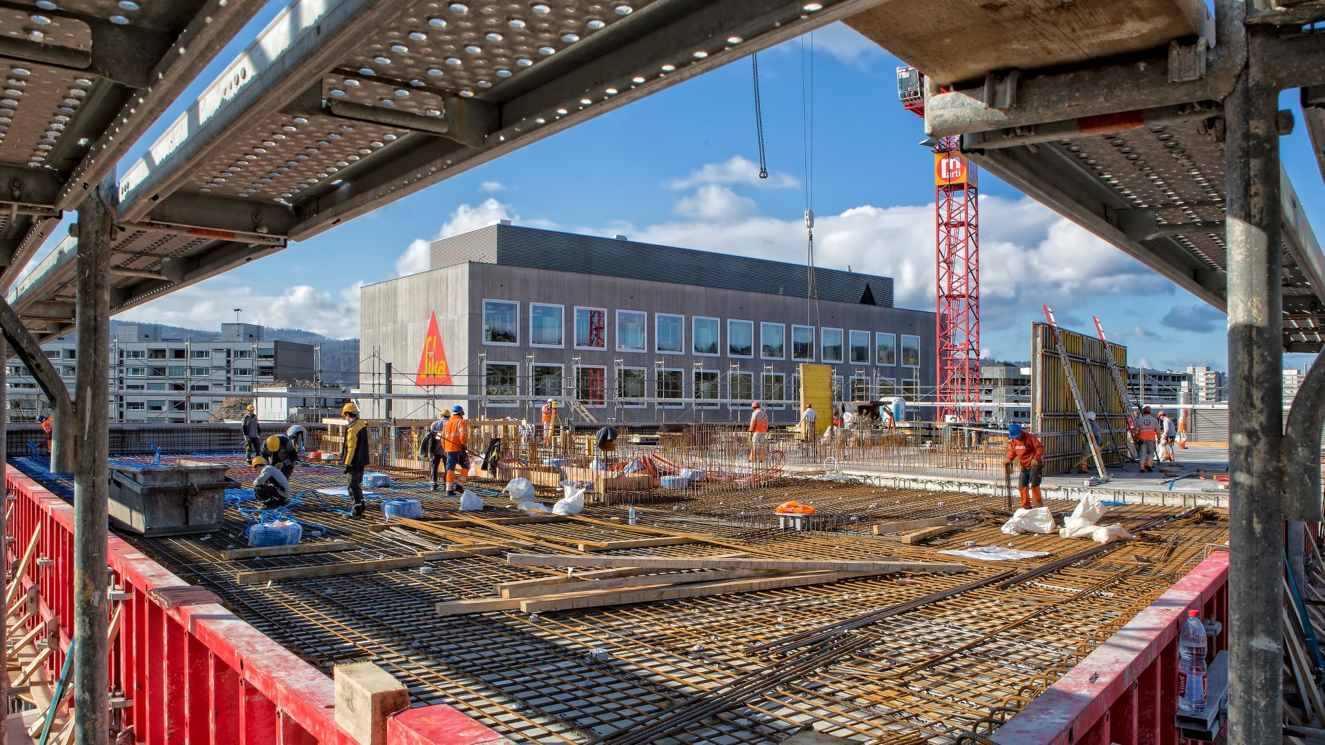 Workers setting up rebar to pour concrete floor on construction site at Limmat building in Zurich