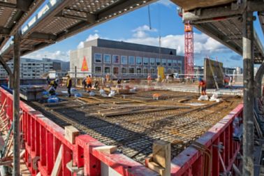 Workers setting up rebar to pour concrete floor on construction site at Limmat building in Zurich