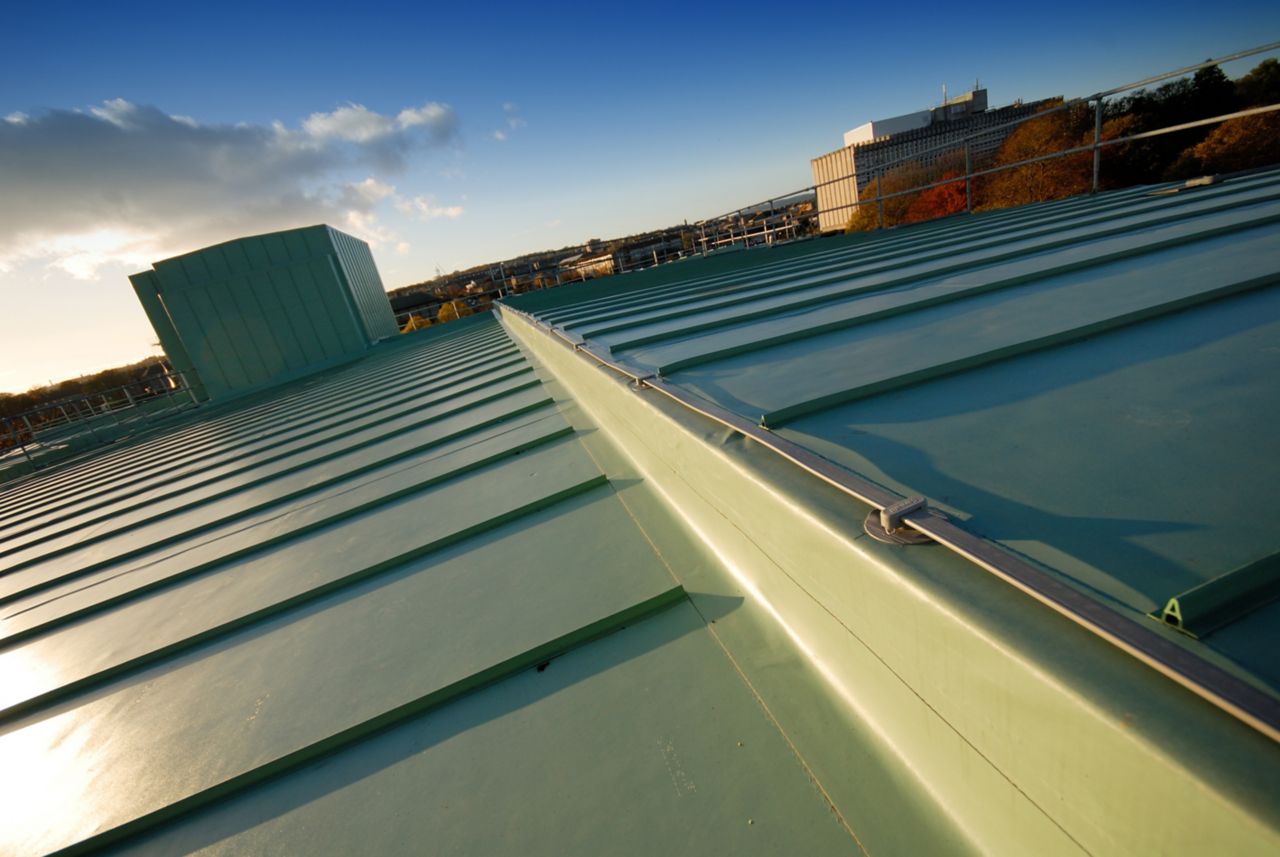 Single-ply roof membrane with metal rib decorative profile seam