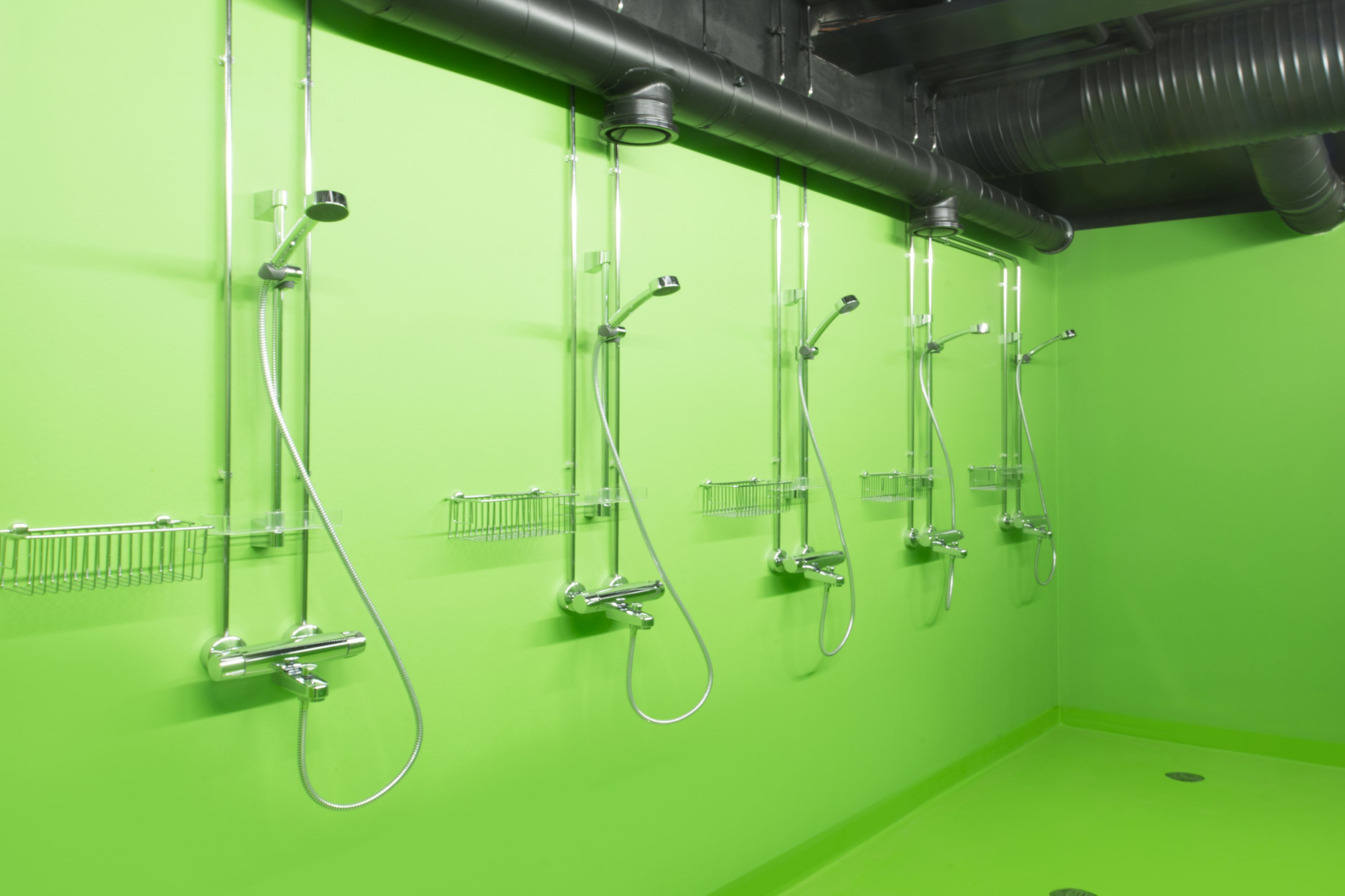 Decorative green bathroom shower floor at Kokkola campus hall school in Finland with Sika ComfortFloor system