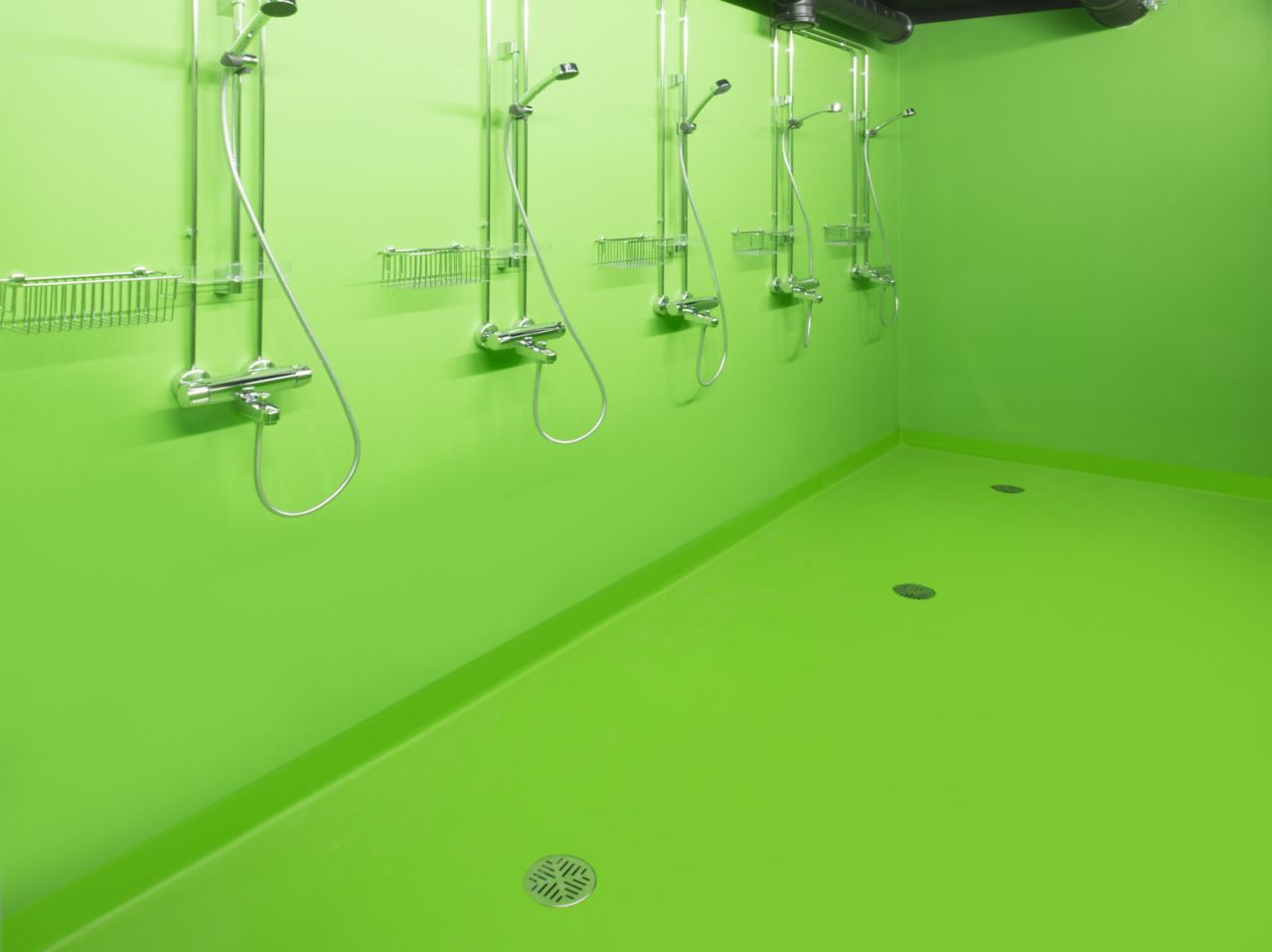Decorative green bathroom shower floor at Kokkola campus hall school in Finland with Sika ComfortFloor system
