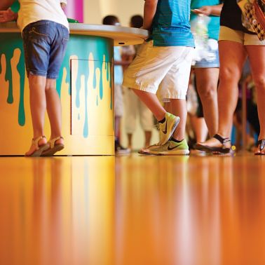 人们站在装饰用西卡舒适地板系统制成的橙色地板上