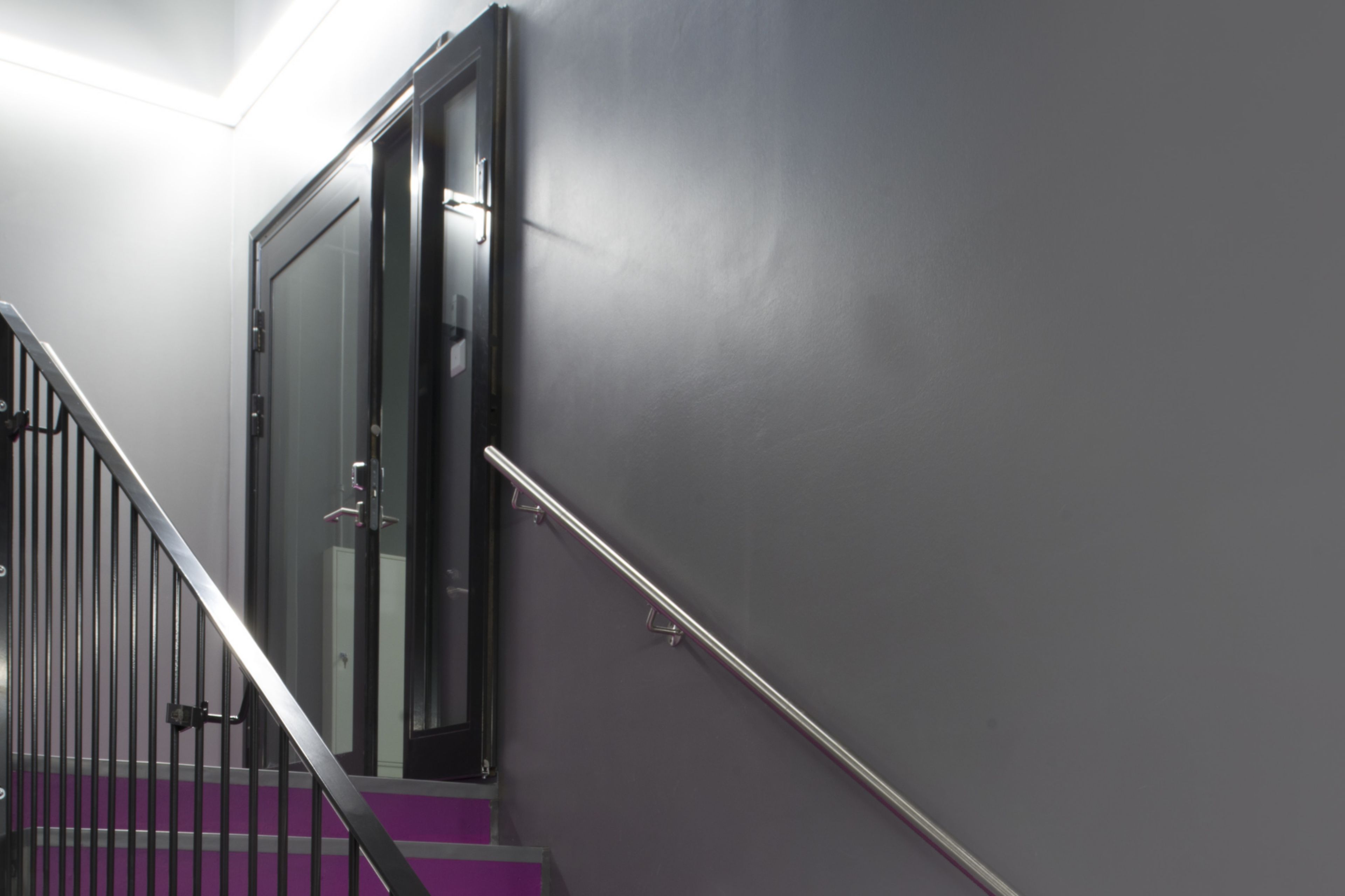 Decorative purple fushia stair floor grey walls at Kokkola campus hall school in Finland with Sika ComfortFloor system
