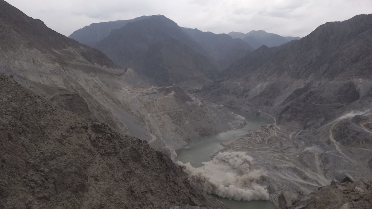 Diamer Basha dam construction blast in Pakistan at lake in valley among mountains