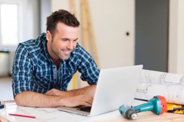 微笑DIY建筑工人与笔记本电脑工作