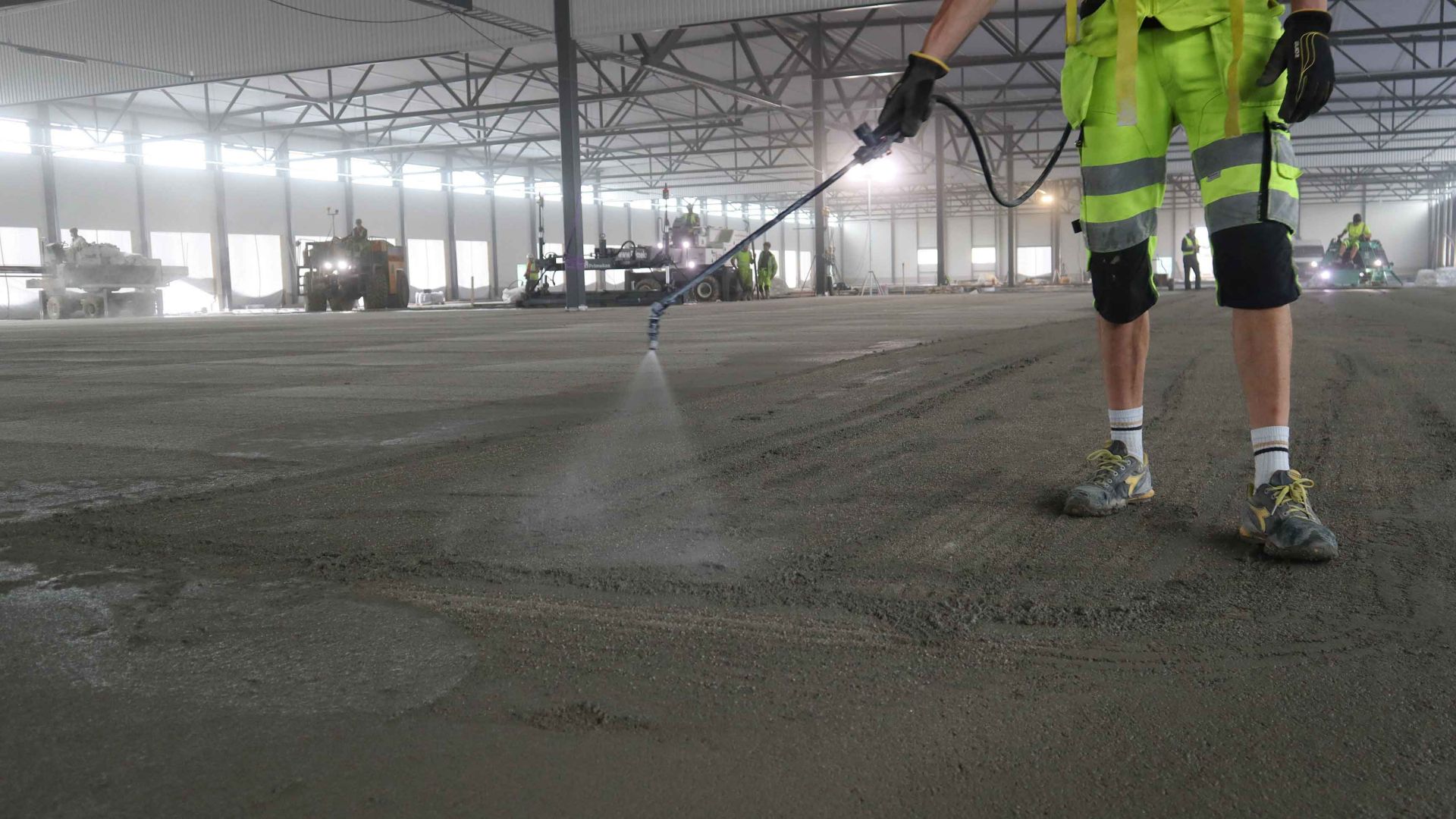 Spray application of finishing aid hardener for concrete floor