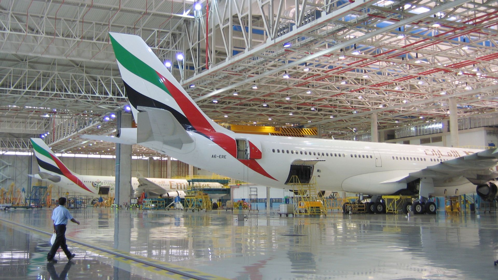 Dubai International Airport Emirates hangar with planes and man walking