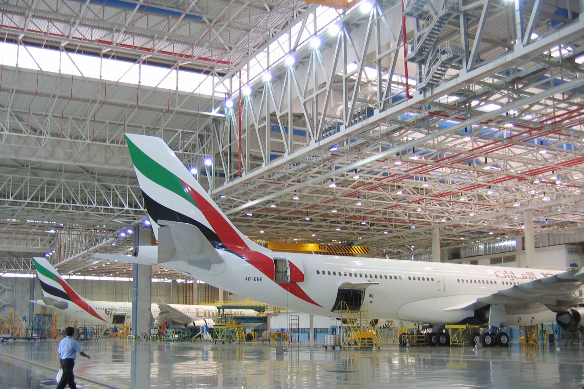 Dubai International Airport Emirates hangar with planes and man walking