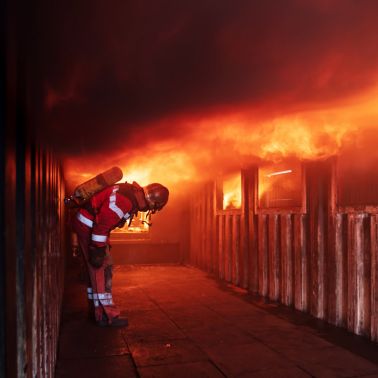 Fireman in front of house on fire