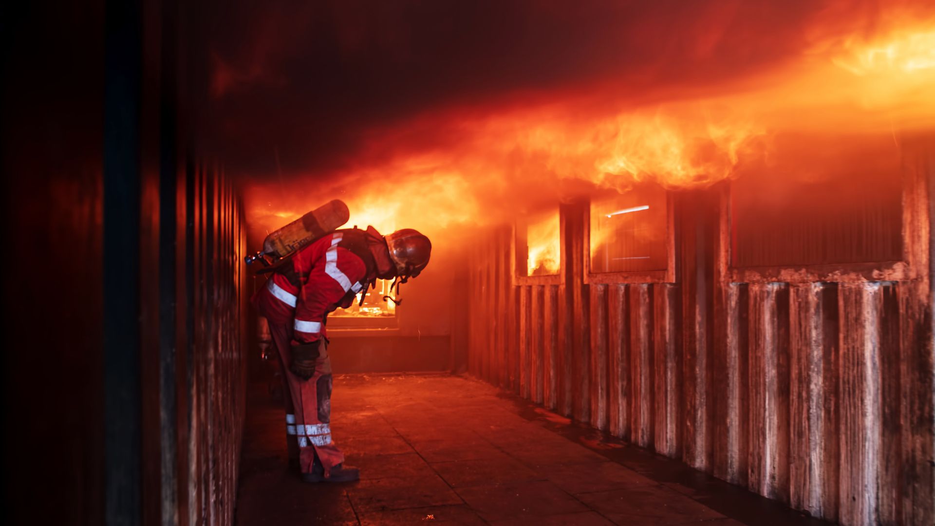 Fireman in front of house on fire