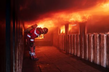 Fireman in front of house on fire