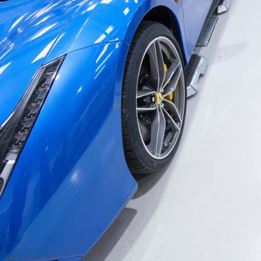 在高光泽Sikafloor表面上的蓝色法拉利汽车